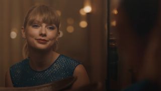 Taylor Swift smiling at herself in a mirror in Delicate video.