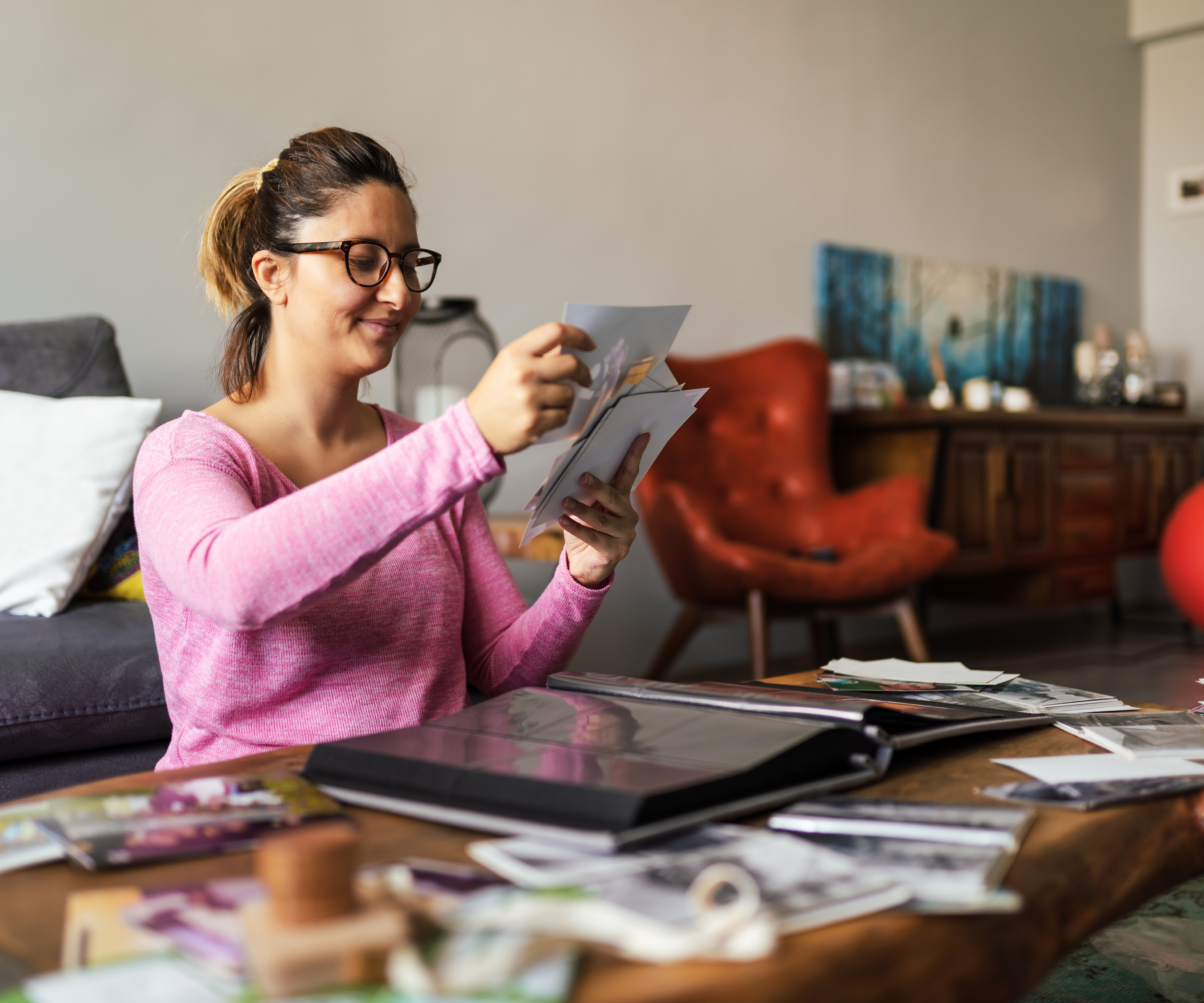 woman looking at photos and putting them into an album