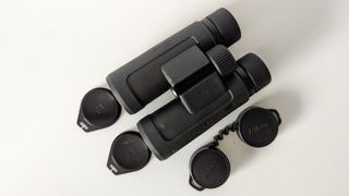 Nikon Prostaff P3 8x42 binoculars on a white table with lens caps laid out