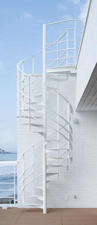 A white spiral staircase on a balcony