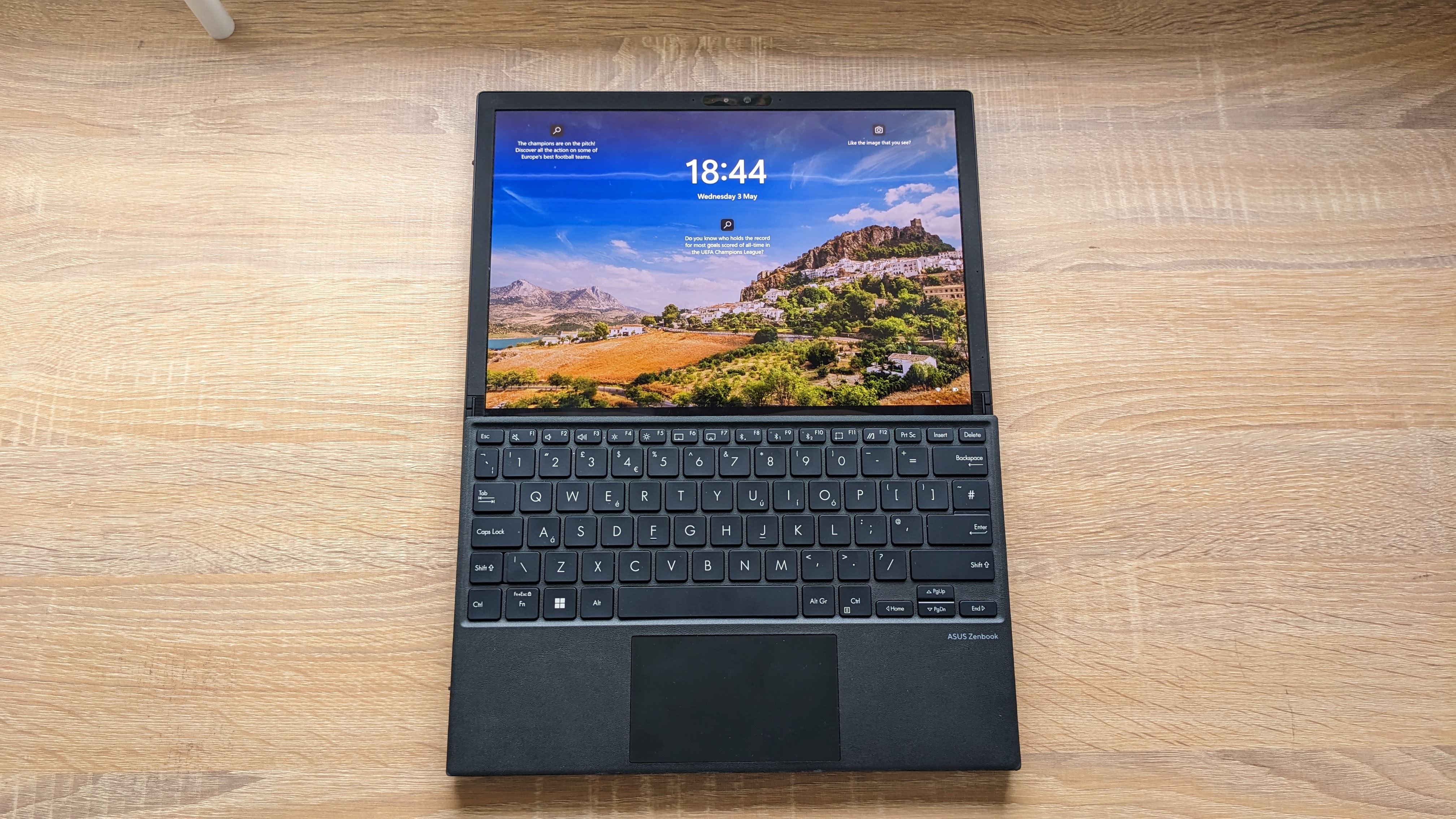 The Asus Zenbook 17 Fold OLED pictured on a wooden desk.