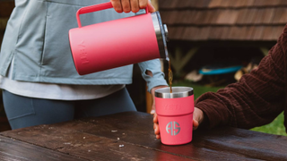 Woman pouring coffee from Yeti French press into Yeti cup