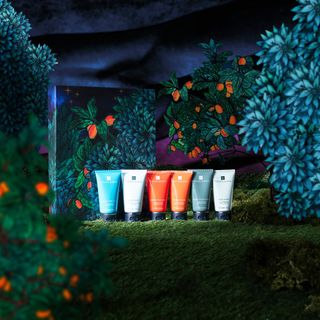 Items from the Templespa The Recharge Spa gift set pictured on a backdrop inspired by a Mediterranean garden at night 