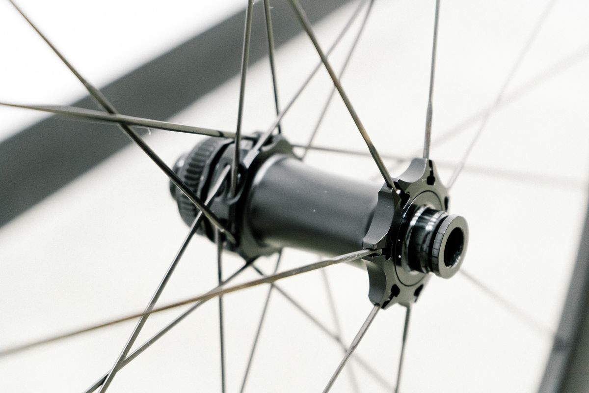 An aero road wheel stands against a white wall