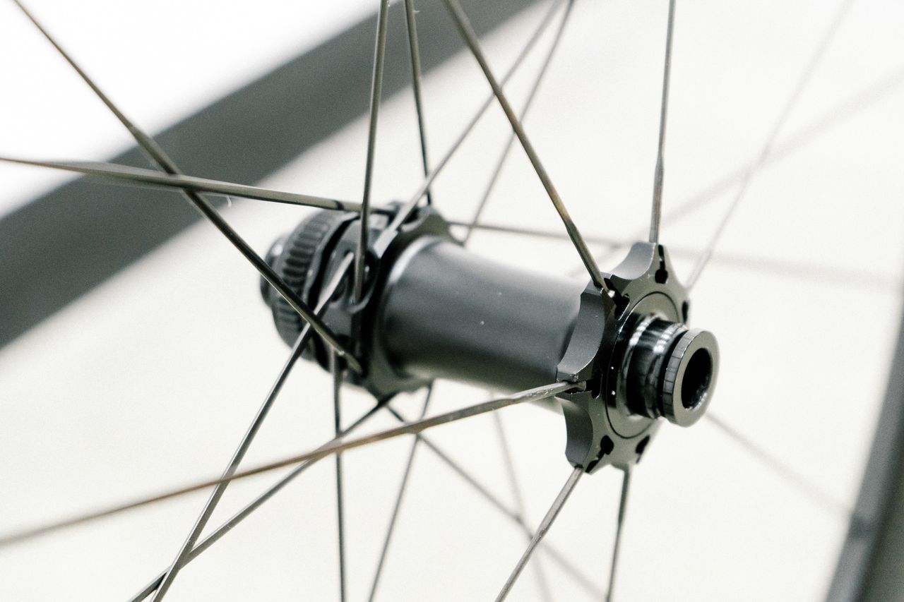 An aero road wheel stands against a white wall