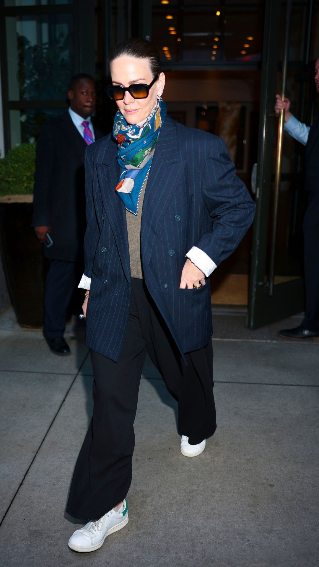 sarah paulson wearing a blazer, trousers and stan smith trainers