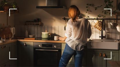 Woman completing low dopamine morning routine early in kitchen with sun coming through window onto counters and plants