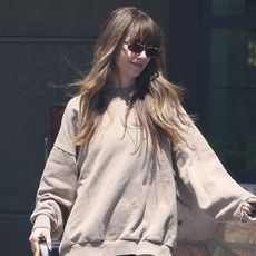 Alison Brie wearing a tan sweatshirt, brown leggings, and tan suede Birkenstock Boston shoes in L.A.