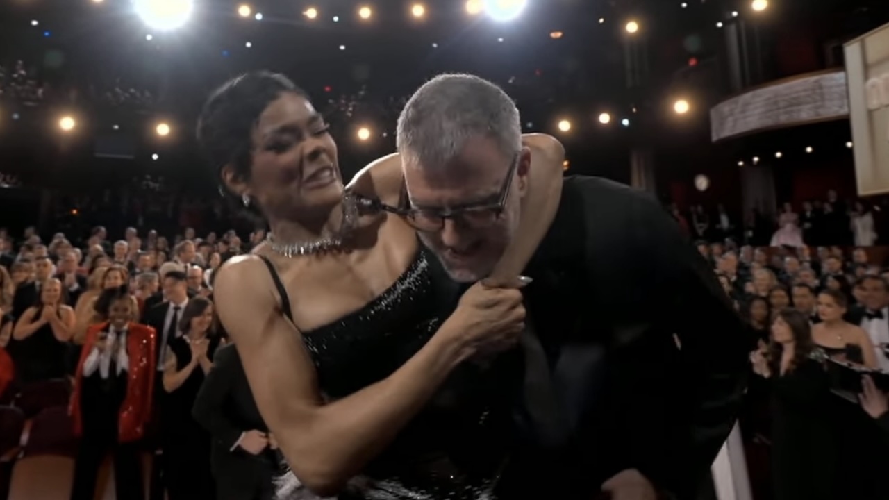 Teyana Taylor hanging on Paul Thomas Anderson's neck at Oscars