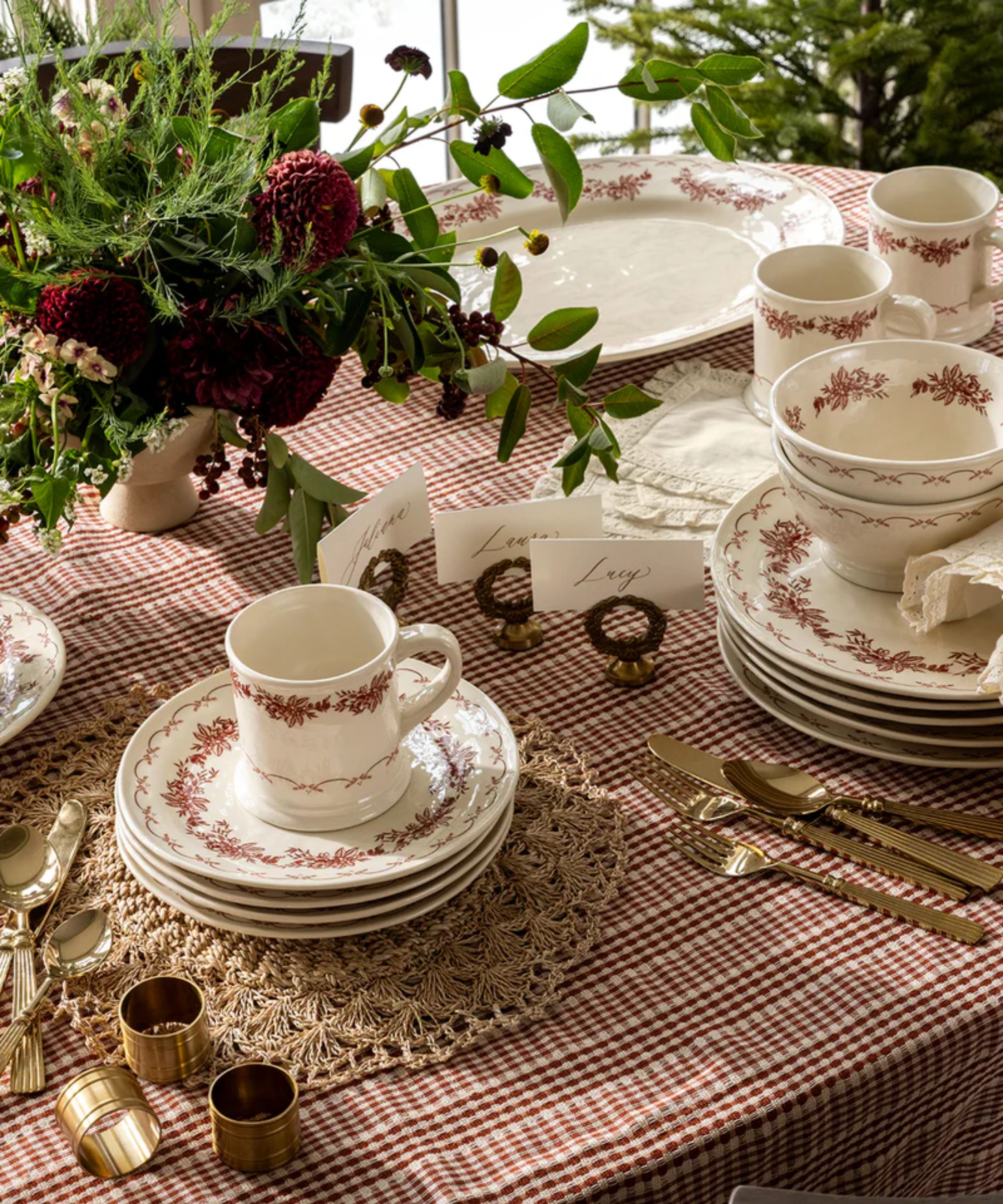Red gingham tablecloth, woven placemats, and red and white floral dinnerware