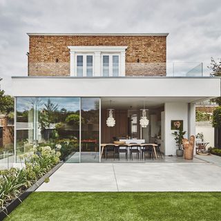 exterior of bungalow with green lawn and potted plant