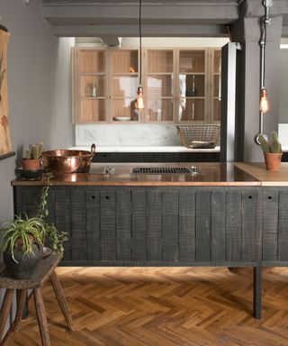 Dark kitchen with wooden herringbone flooring