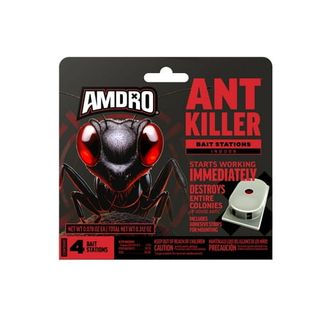 A cardboard box of ant bait with a large black ant with glowing red eyes on the front. 