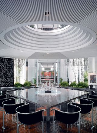 The dining room, with Portman’s ‘Entelechy’ chairs and a glass sculpture by Hans Frabel, is located in a glass pavilion set in a reflecting pool.