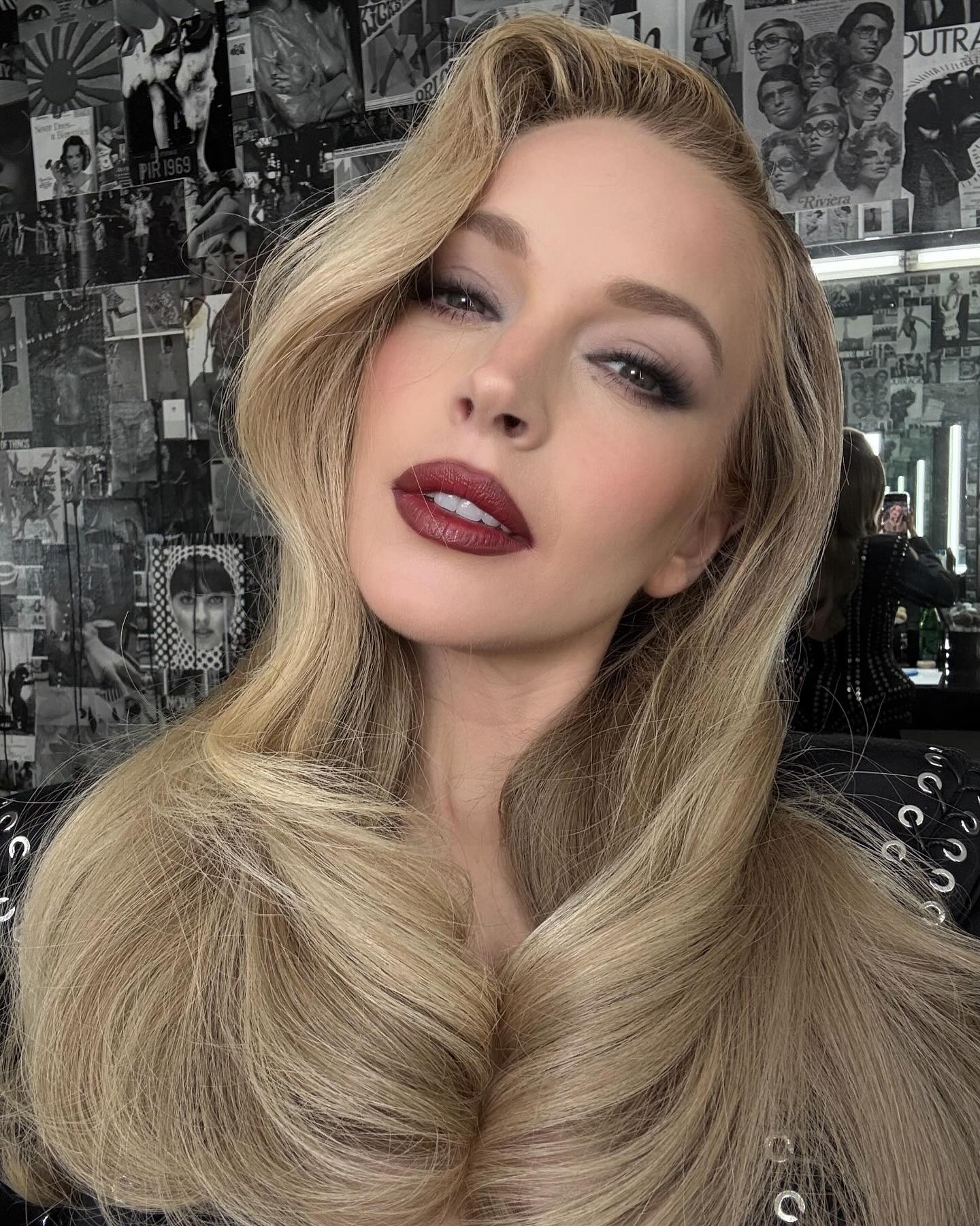 Lindsay Lohan with long blonde hair styled in an old Hollywood-inspired blowout.