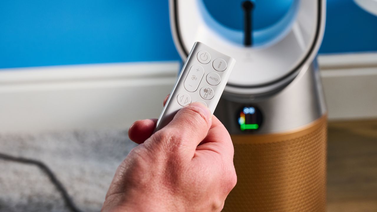 The Dyson Find+Follow Purifier Cool PC3 remote in hand