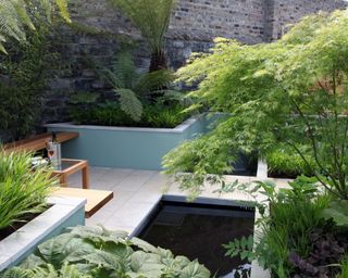raised garden beds and pond in a small patio garden