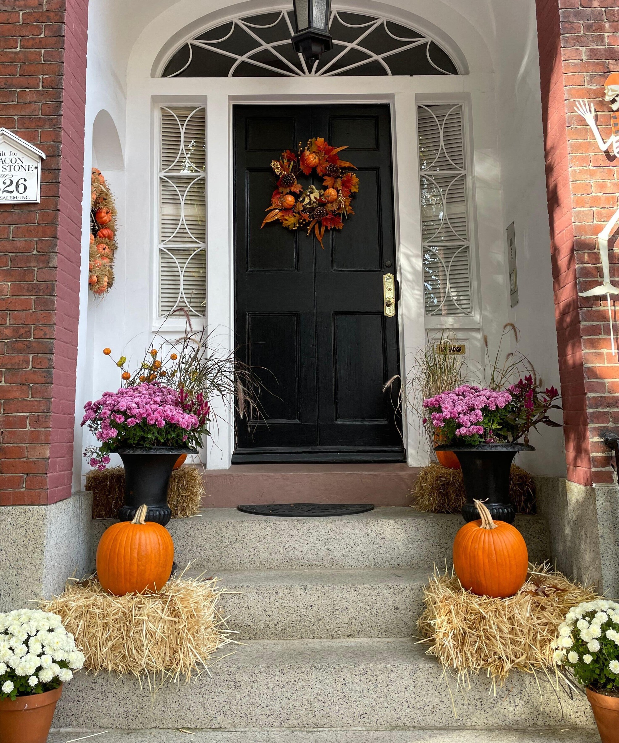 Fall porch display with pumpkins, hay bales, mums, peppers and grasses