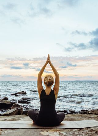 Woman doing a yoga pose on a beach