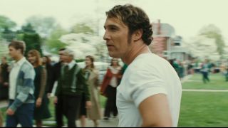 Matthew McConaughey in a white t-shirt with long sideburns in We Are Marshall