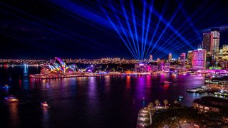 Long exposure of Sydney Harbour buildings lit up with coloured lights during Vivid Sydney