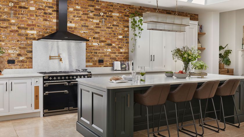 large kitchen with large kitchen island and pot filler and exposed brick wall