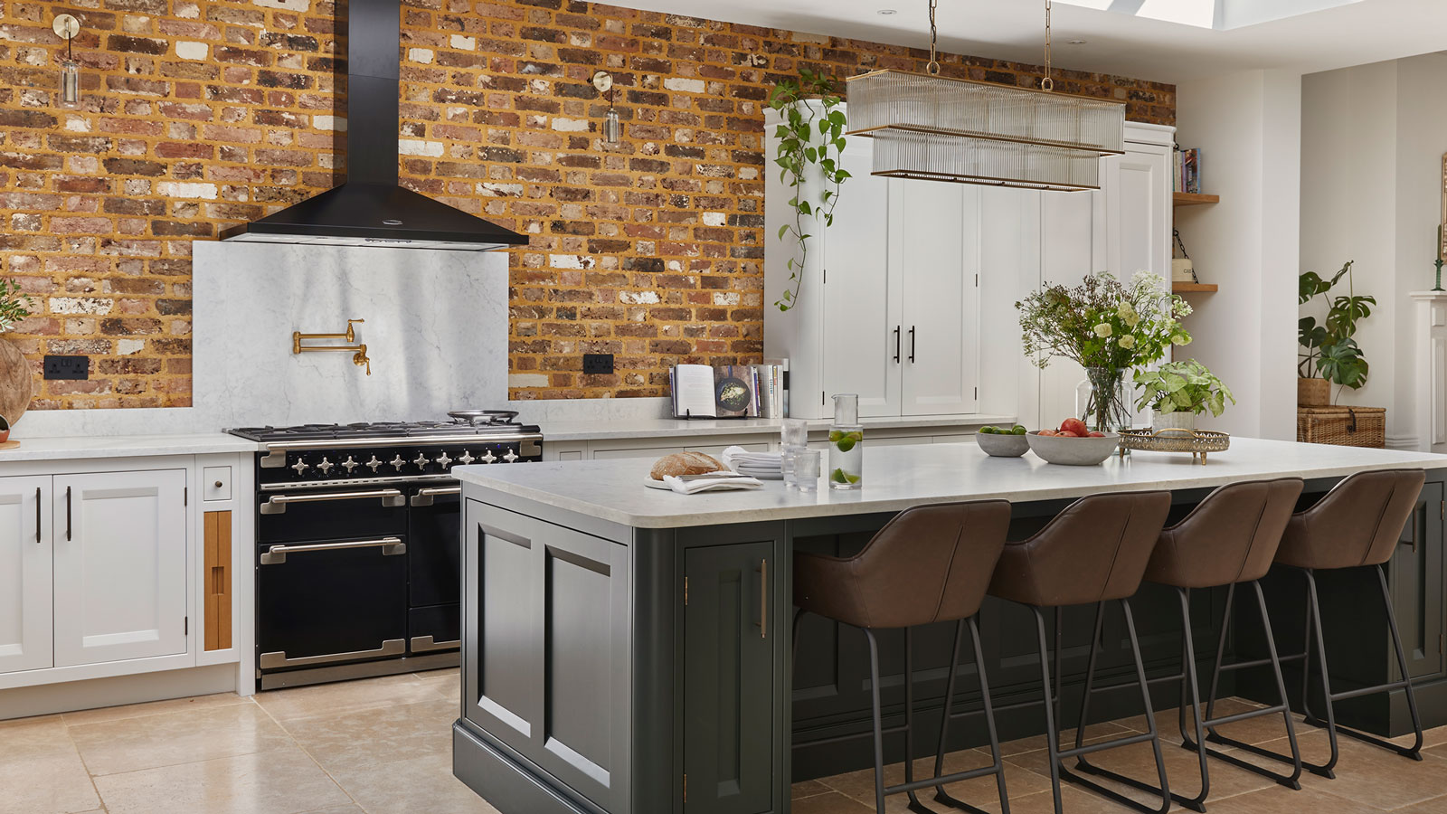 large kitchen with large kitchen island and pot filler and exposed brick wall