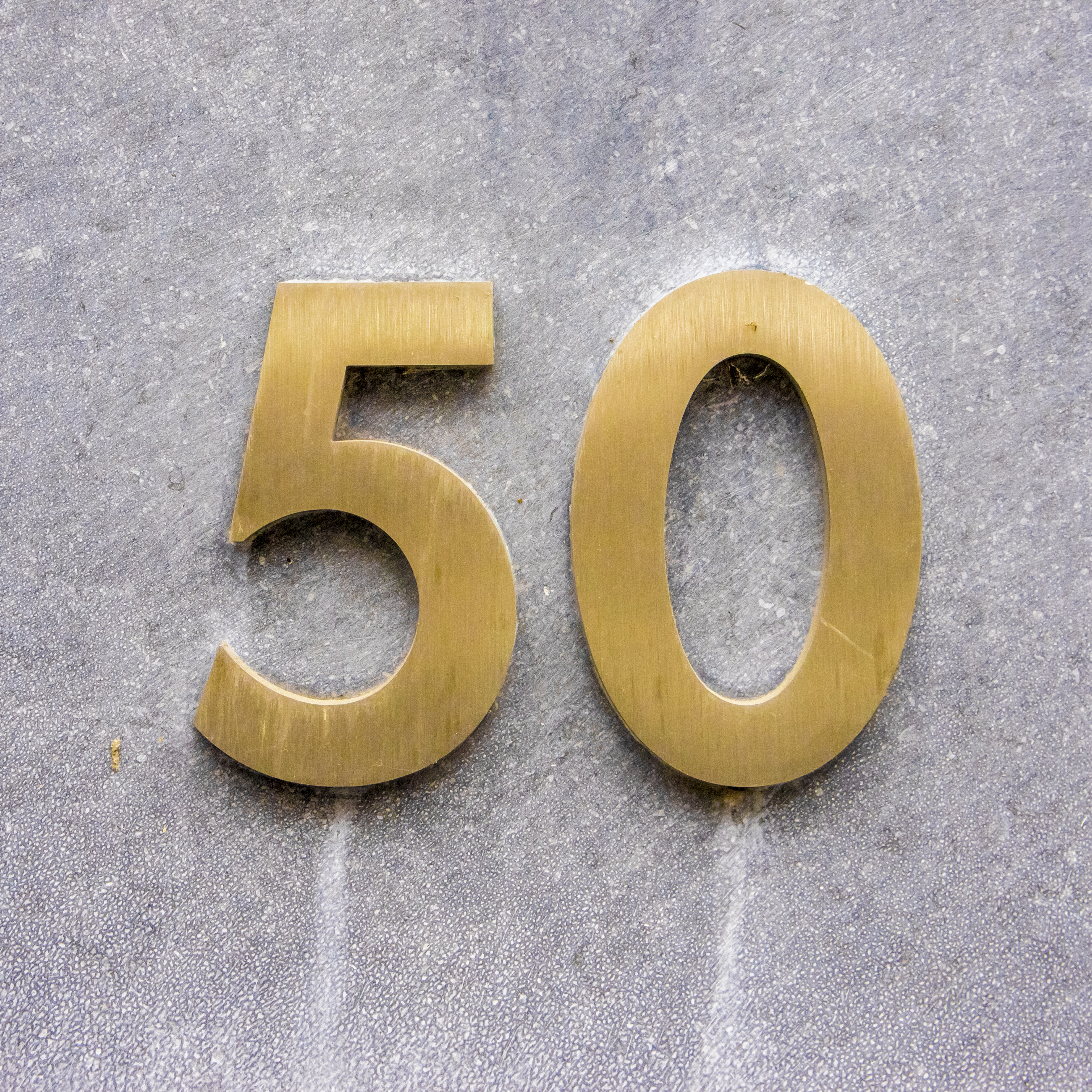 the number 50 in gold numerals on a gray background