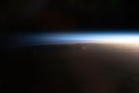 The edge of the Earth glows in twilight as seen from space