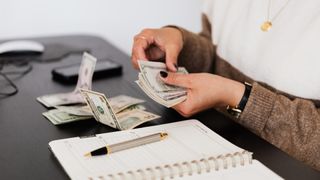 Woman counting money at desk