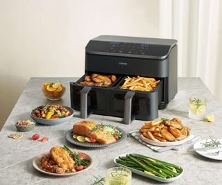 Cosori Dual Drawer Air Fryer on the countertop with air fried food on plates in front of it