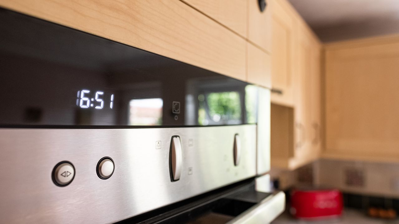 Shallow focus of a digital display seen on a modern built-in cooker seen in a kitchen