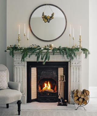 Christmas mantel decor ideas with relaxed pine branches on a white fireplace