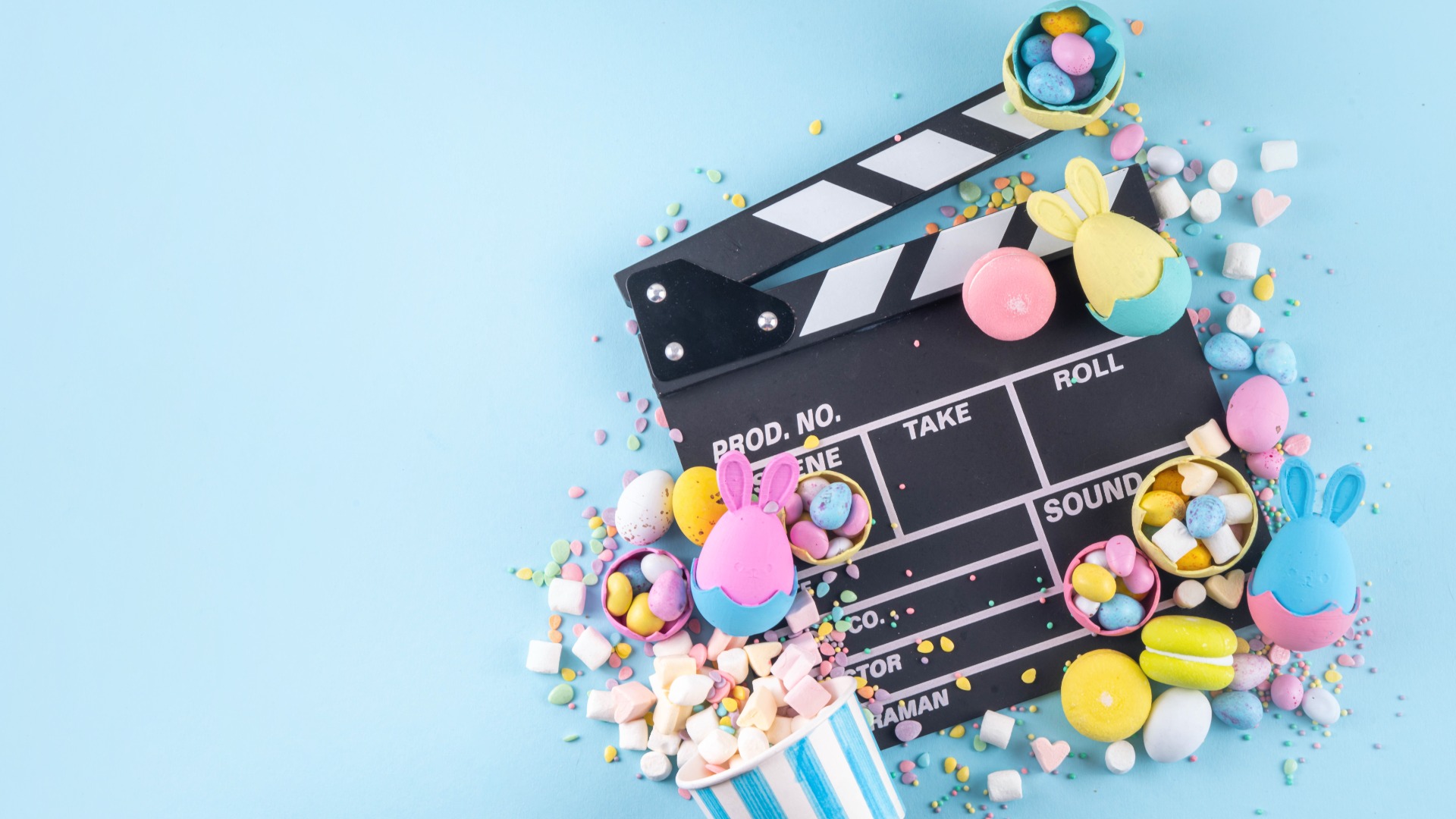Cinema clapper-board with Easter chocolate egg. popcorn and marshmallow