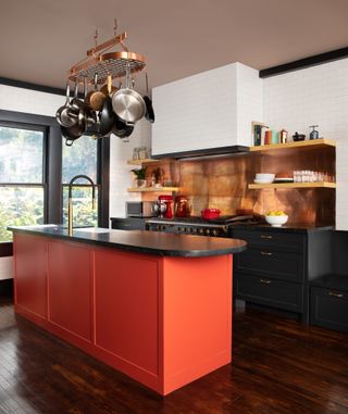 A small kitchen with a bright island and a copper splashback