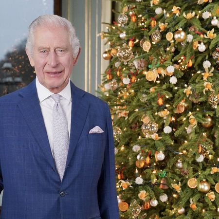 Kate Middleton wears a long red coat as she attends the Christmas Carol concert and King Charles smiles next to a Christmas tree in Buckingham Palace