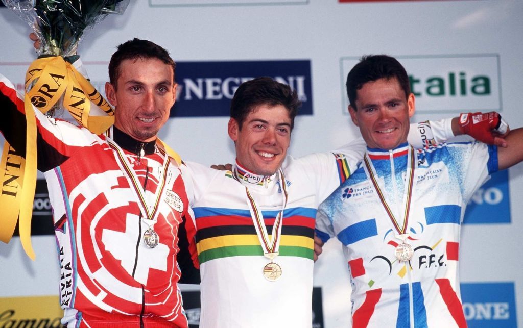 Spain's Oscar Freire celebrates his 1999 road race World Championships victory on the podium with Switzerland's Markus Zberg and Frenchman Jean-Cyril Robin
