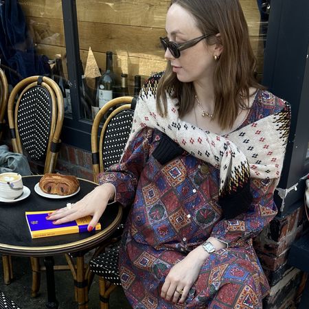 Erika Veurink posing with her debut novella at a cafe