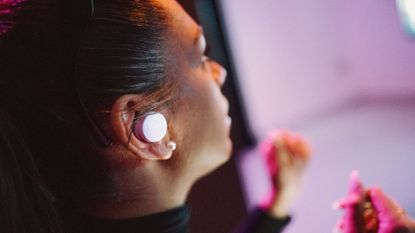 A woman wearing the Denon PerL earbuds