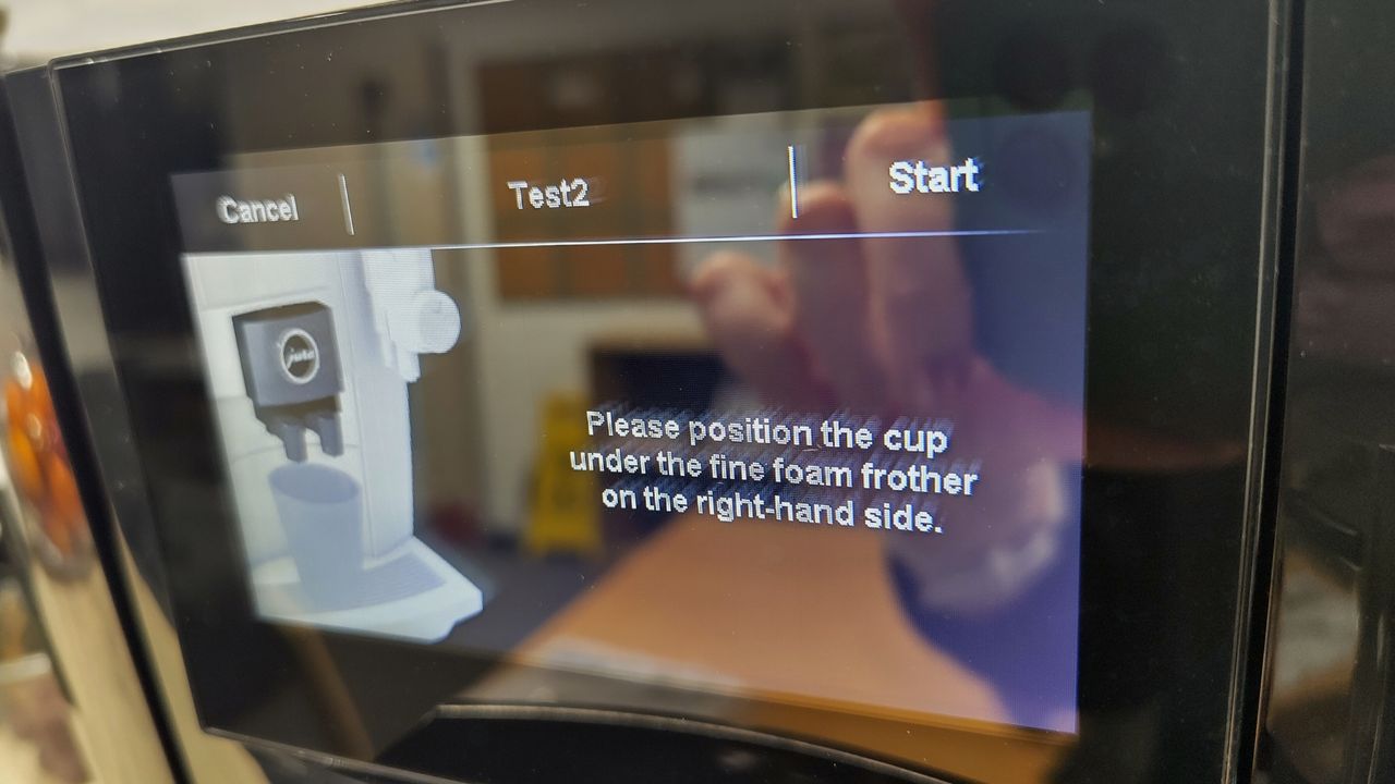 Instructions for positioning cup on Jura J10 coffee maker