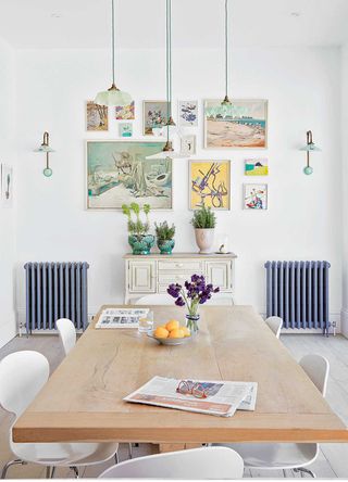 white kitchen with retro artwork and wall lamps to support the kitschen trend