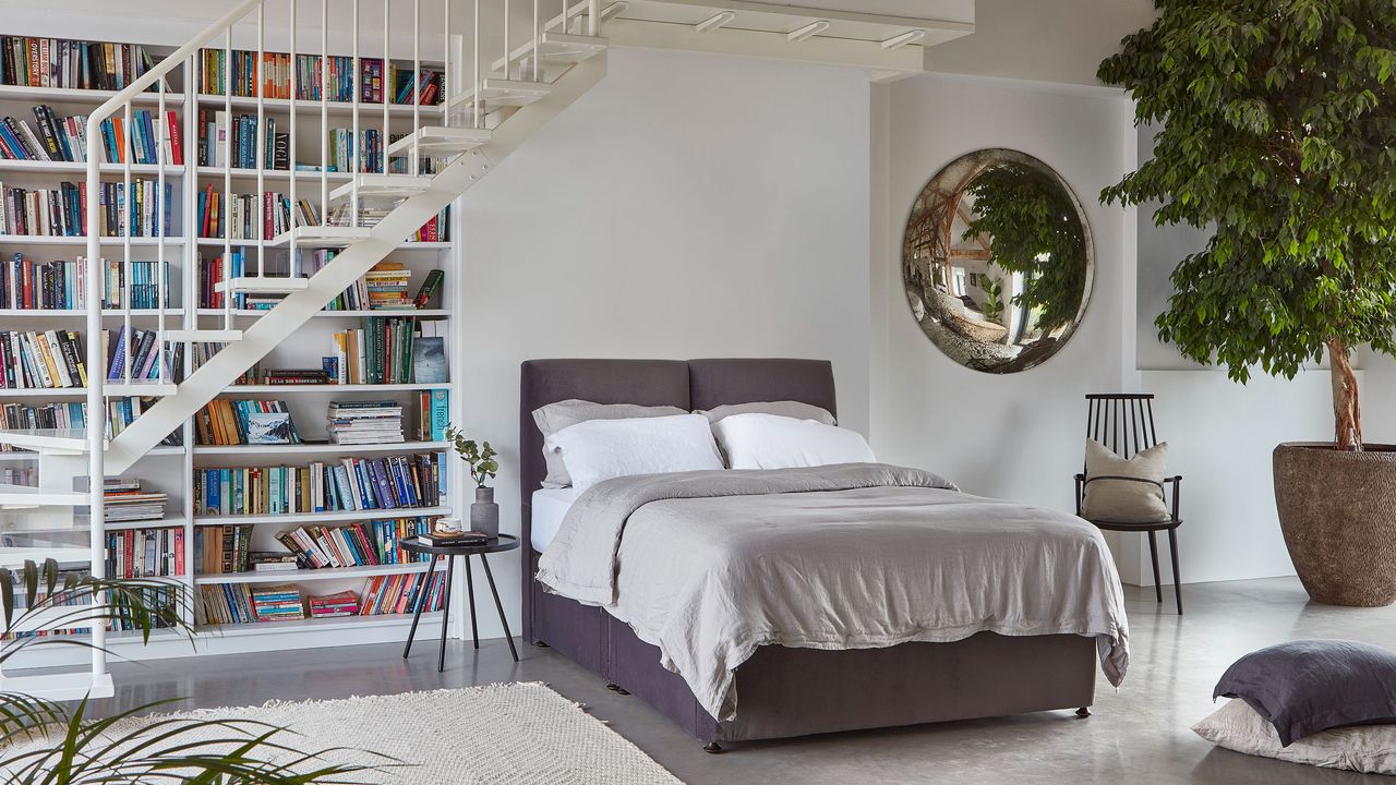 An apartment with bookshelf, white metal staircase and bed with Melksham 3000 Pocket Sprung Mattress