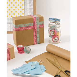 glass jar with ceramic lid brown paper packages with strips of decorative tape and gold scissors