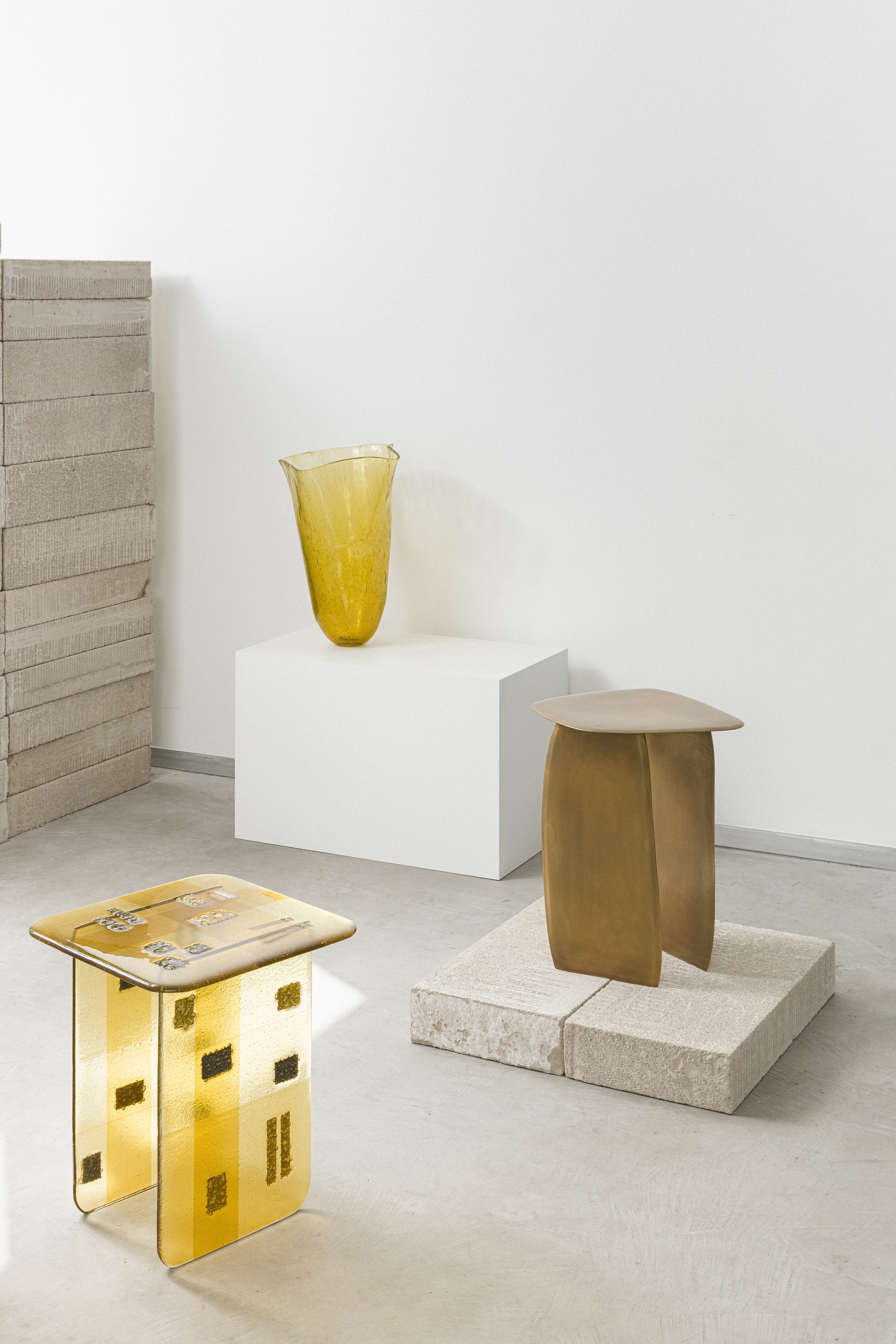 A series of organically shaped stools in semi-transparent glaze in yellow and beige.