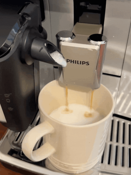 GIF of an espresso shot being brewed into a white coffee mug from a Philips fully automatic coffee machine.