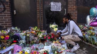 A man lays flowers at the scene of Elianne Andam's murder in Croydon