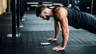a photo of a man using one of the best workout apps in the gym 