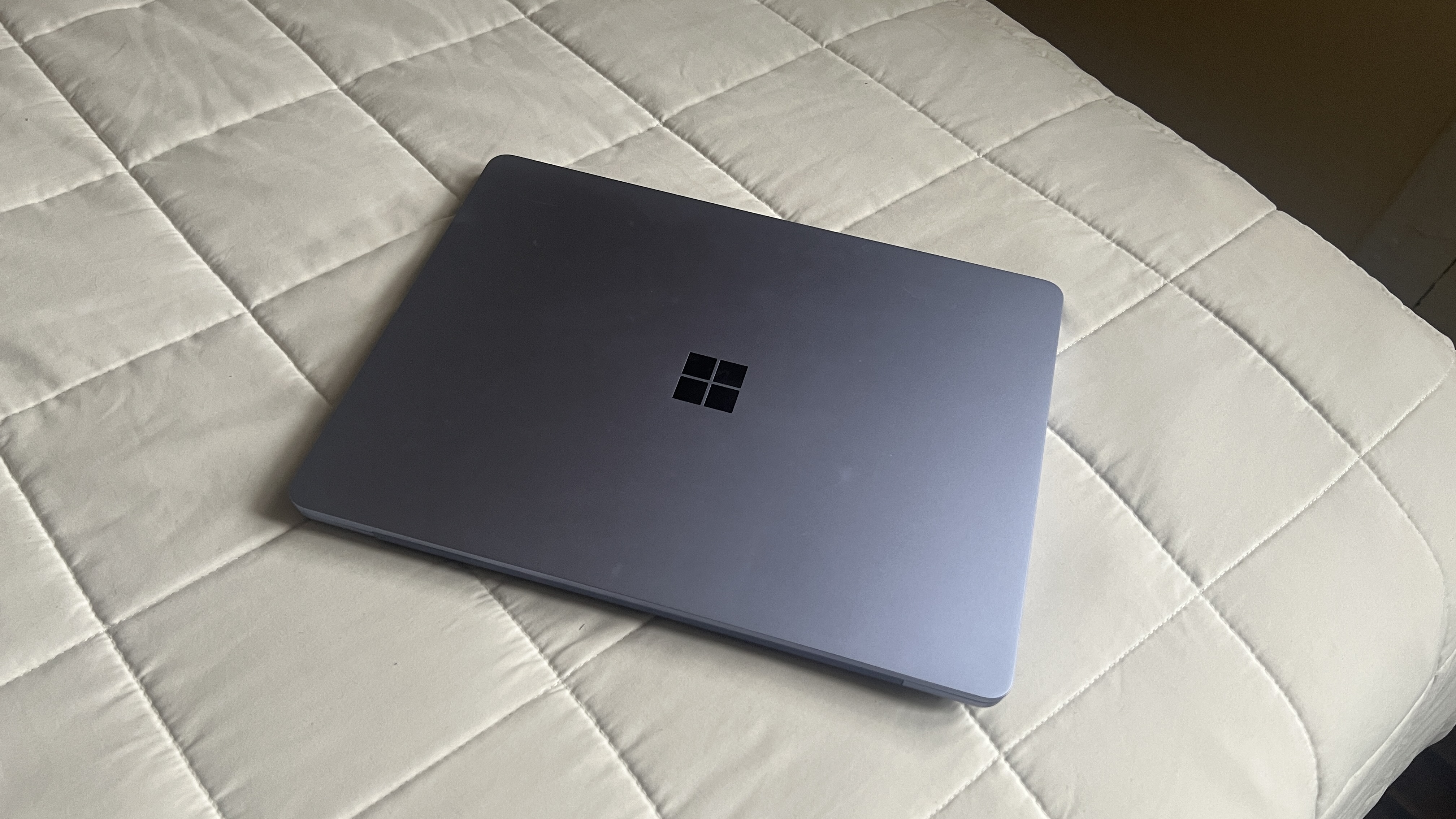 A Microsoft Surface Laptop 13-inch on a bed