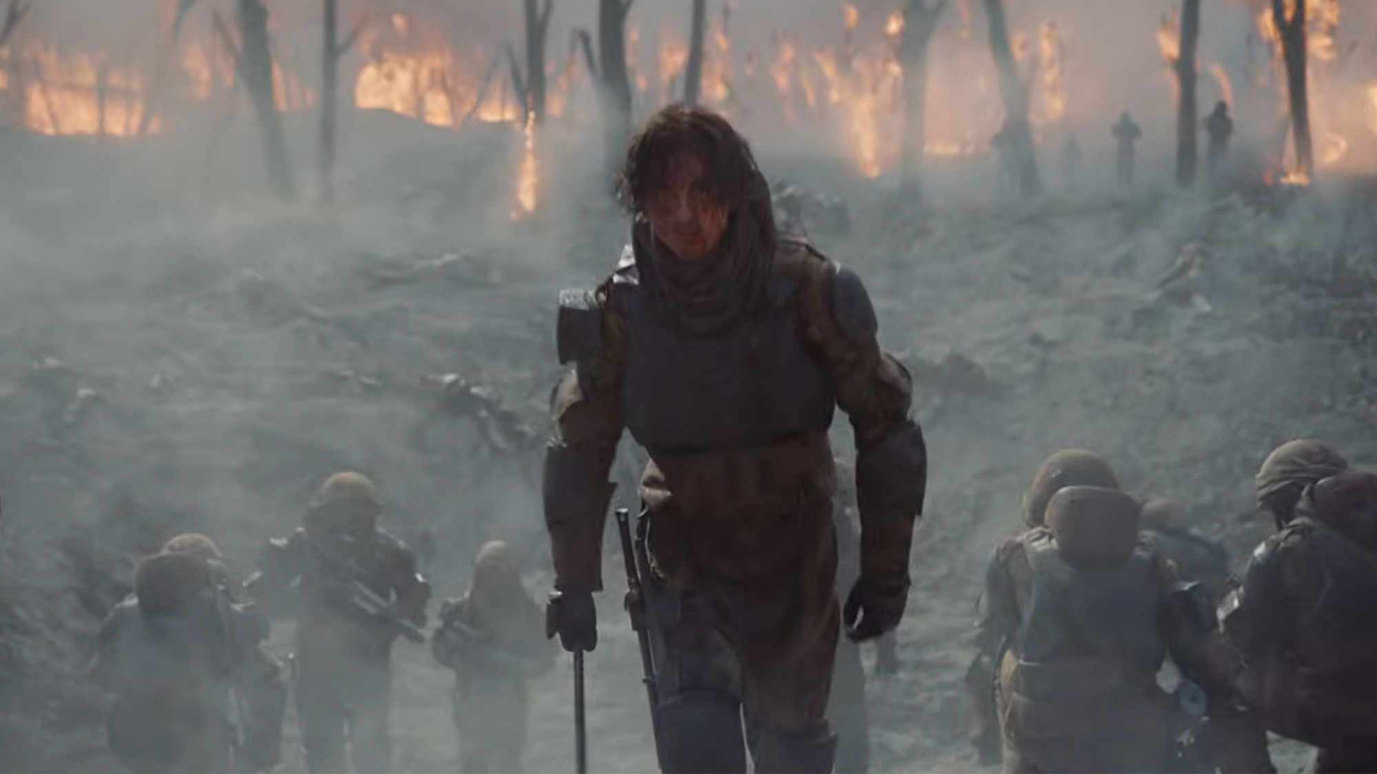 Timothee Chalamet walking in a dark uniform on a battlefield in Dune Part 3