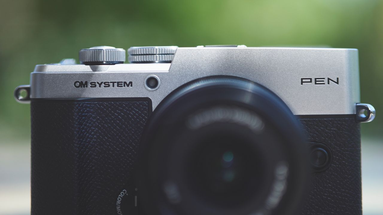 Top half of the OM System PEN camera, from the front